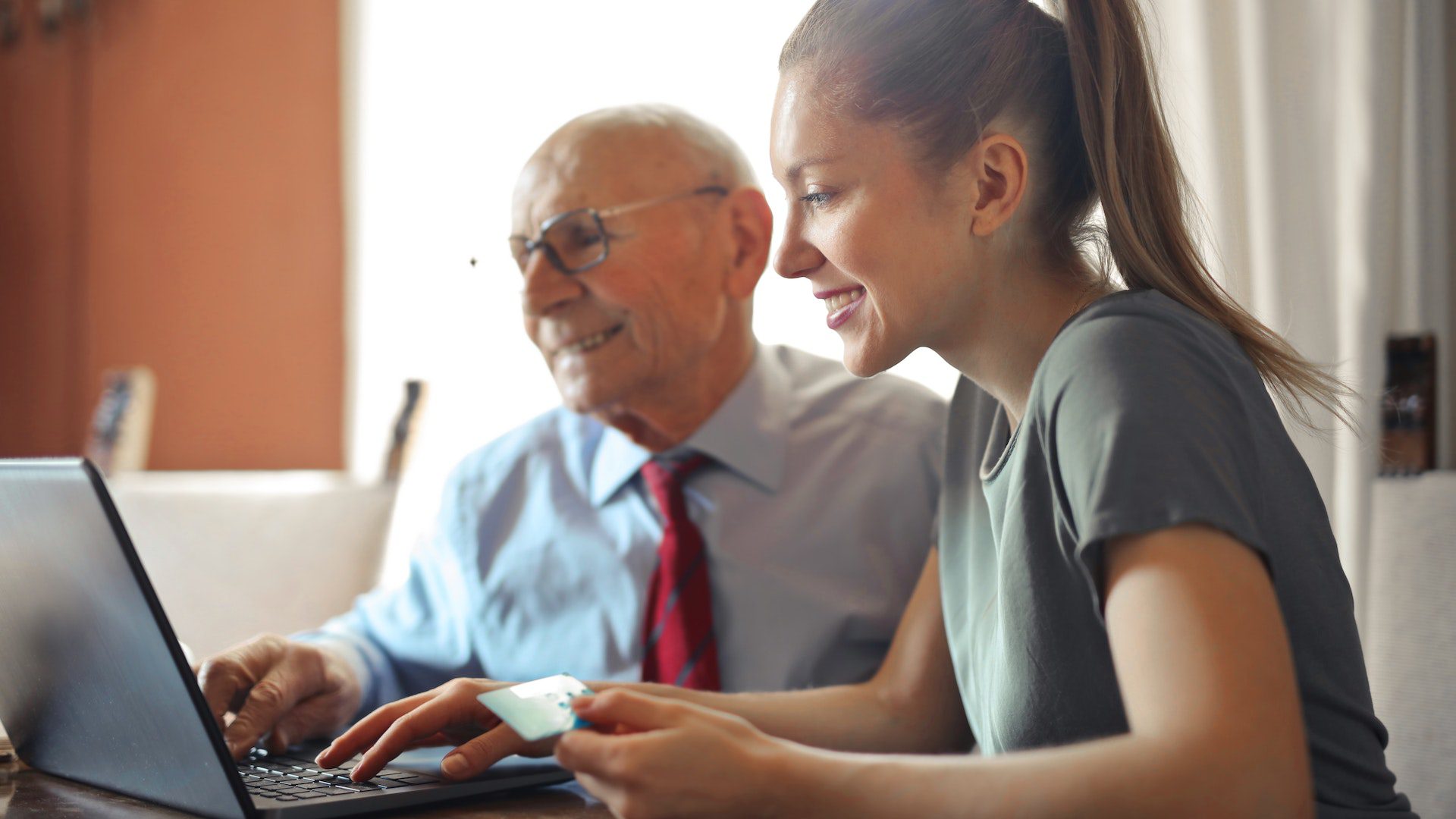 Business Services young woman helps elderly men using laptop